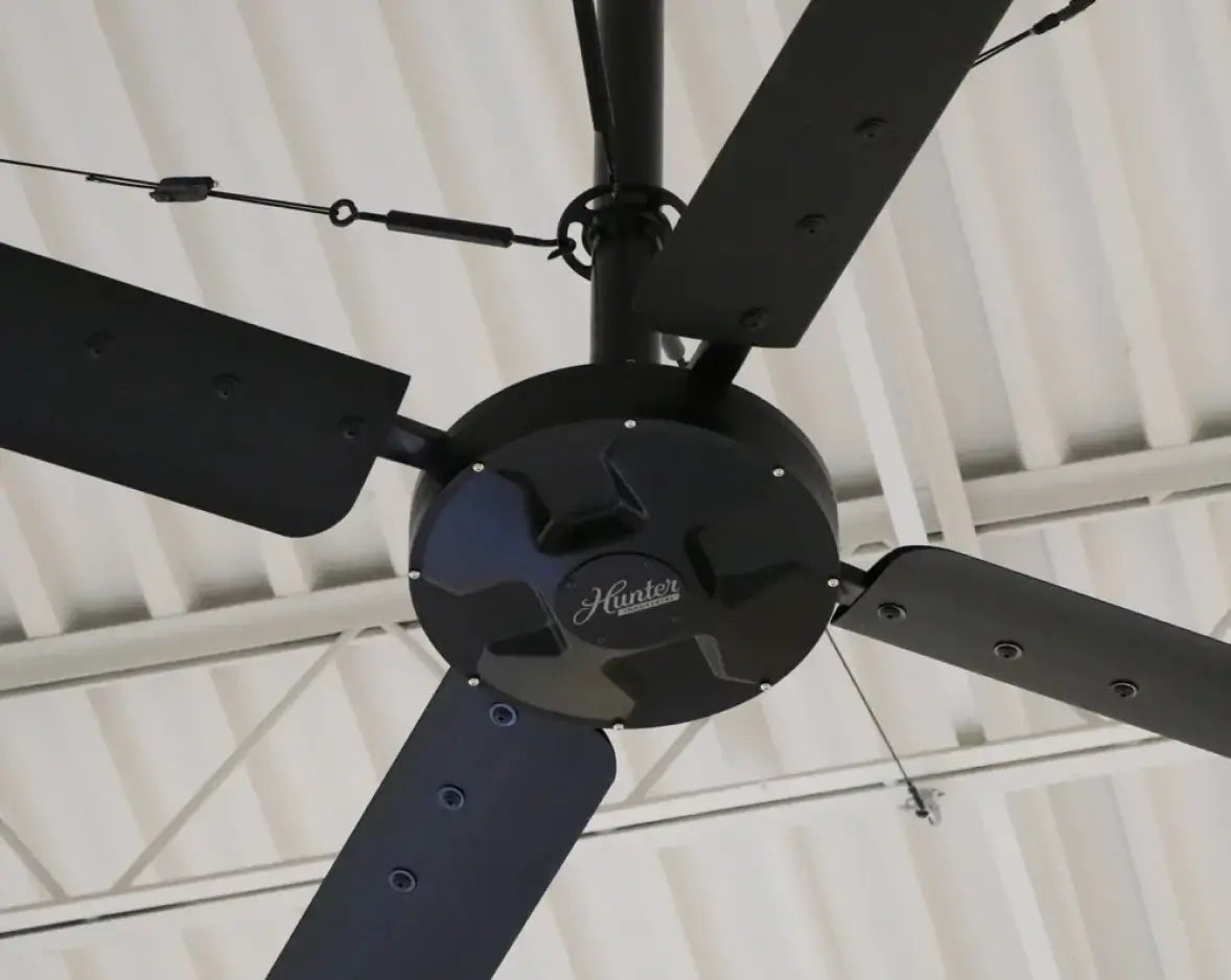 Hunter Industrial ECO HVLS fan motor and blades close-up, mounted to corrugated steel ceiling